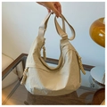 Detail of beige crescent crossbody bag featuring woven zipper pull and adjustable strap - Off White