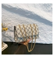 Close-up of cream crossbody bag with black floral pattern and gold chain strap - White