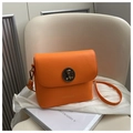 Retro orange leather crossbody bag featuring a vintage round bronze buckle and gold lettering - Orange