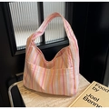 Close-up of pink and yellow striped seersucker canvas bag with wide shoulder strap - Pink