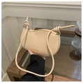 Detailed close-up of a cream saddle bag featuring a knotted strap and gold branding - Rose Pink