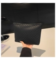 Minimalist large black clutch bag with woven texture pattern held by hand - Black