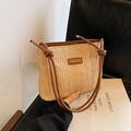 Handgefertigte beige Strohbeuteltasche mit braunen Lederriemen und modischem Etikett - Stroh Braun
