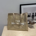 Beige mesh beach tote bag with The Beach Bag lettering in a modern minimalist design - Khaki With White Lettering