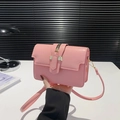 Minimalistische rosa Umhängetasche mit Glanzeffekt und Metallschnalle im modernen Interieur - Rosa