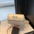 Bolso bandolera dorado con lentejuelas plateadas, acabado mate y detalle de lazo - Dorado