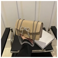 Detailed shot of beige faux leather handbag with sparkling rhinestone bow and silver chain - Khaki