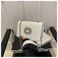 Close-up of white V-quilted small square bag with crystal buckle and silver chain - White