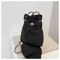 Close-up of black drawstring bucket bag featuring silver eyelets and high-quality nylon texture - Black