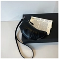 Detail view of black crescent bag with pleated leather texture on a minimalist background - Black