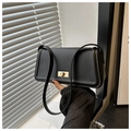 Close-up of matte black leather handbag with a golden rectangular turn-lock buckle - Black