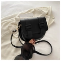 Bolso de hombro negro mate con hebilla doble y detalles dorados sobre fondo de traje beige - Negro