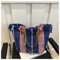 Dettaglio borsa intrecciata blu navy con strisce rosse e bianche, nappe e manici marroni - Blu