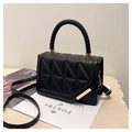 Detalle de bolso acolchado negro con asa trenzada y herrajes metálicos dorados - Negro