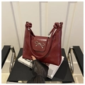 Macro shot of glossy burgundy patent leather bag with silver bow buckle and knotted strap - Burgundy