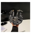 Detail of zebra print crescent bag featuring a bow handle and elegant gold buckle - Zebra Print