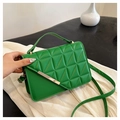 Close-up of green quilted faux leather handbag with triangle stitching and gold metal trim - Green