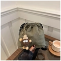 Detail of army green nylon bucket bag with drawstring closure and cute plush monster charm - Green (With Plush Pendant)