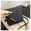 Detail view of black quilted faux leather crossbody bag with elegant gold metal accent - Black