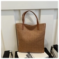 Brown woven straw tote bag with dark leather handles and a textured V-pattern design - Brown