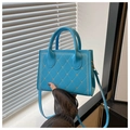 Dettaglio della borsa trapuntata blu acceso con borchie a cuore dorate e tracolla regolabile - Blu