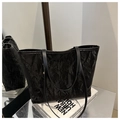 Detail of black tote bag featuring crinkled glossy texture and leather shoulder straps - No Pendant / Black