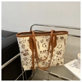 Detail of a large tote bag with retro graffiti prints and brown leather trim accents - Brown Without Pendant