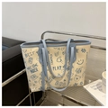Detail of vintage graffiti print tote bag with blue trim on stainless steel shelf - Blue Without Charm