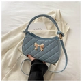 Quilted light blue crescent bag with golden bow detail and top handle design - Blue