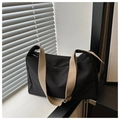 Detalle del bolso tote de lona negra con correa beige ancha y bolsillo lateral práctico - Negro