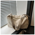 Detalle de la hebilla metálica y correa de un bolso tote de nailon beige ajustable - Blanco