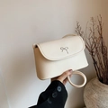 Creamy beige bow accent shoulder bag with minimalist circular strap and smooth faux leather - White