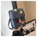 Close-up of blue denim phone bag featuring heart patches and pink ribbon detail - Blue