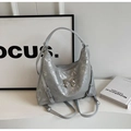 Detail of silver metallic tote bag with cracked texture and a metal bow ornament - Silver