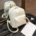 Mini cream PU leather backpack with adjustable straps and front pocket shown in mirror - White Without Pendant