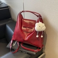 Detalle de bolso tote granate con textura de cera al óleo, lazo y colgante de peluche - Rojo Vino (Con Colgante de Nube)