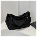 Detalle del bolso tote de lona negra con cordones laterales ajustables y asas resistentes - Negro
