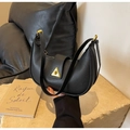 Detalle del bolso de media luna en cuero negro con cierre de triángulo dorado - Negro