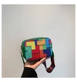 Detail of colorful geometric block pattern on a green shoulder bag with wide strap - Green