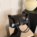 Minimalist black glossy shoulder bag with vertical stripe texture and knotted strap detail - Black