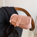 Pink minimalist crossbody bag with horizontal texture and knot strap on a wooden chair - Pink