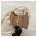 Detailaufnahme der beigen Handtasche aus Kunstleder mit Goldverschluss und Kettenriemen - Khaki
