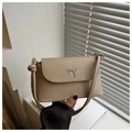Close-up of beige leather shoulder bag with a silver bow logo and knotted strap detail - Khaki