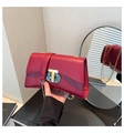 Dettaglio borsa a tracolla in pelle rosso scuro con chiusura dorata e tracolla a catena - Rosso