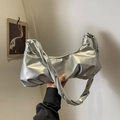 Silver metallic pleated cloud bag with twisted strap shown in a minimalist setting - Silver
