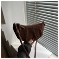 Detalle de un bolso croissant de ante marrón con textura plisada y nudos decorativos - Marrón