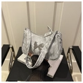 Macro detail of silver pleated fabric and large metal butterfly clasp on shoulder bag - Silver