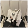Detail of white pleated hobo bag featuring a large silver metal butterfly ornament - White