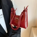 Bolso de hombro en charol rojo oscuro con detalle de lazo plateado y asa anudada - Rojo