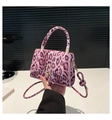 Close-up of pink leopard print crossbody bag featuring gold metal turn-lock and knot strap - Pink